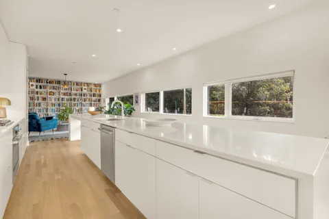 a kitchen with stainless steel appliances granite countertop a sink and white cabinets with wooden floor