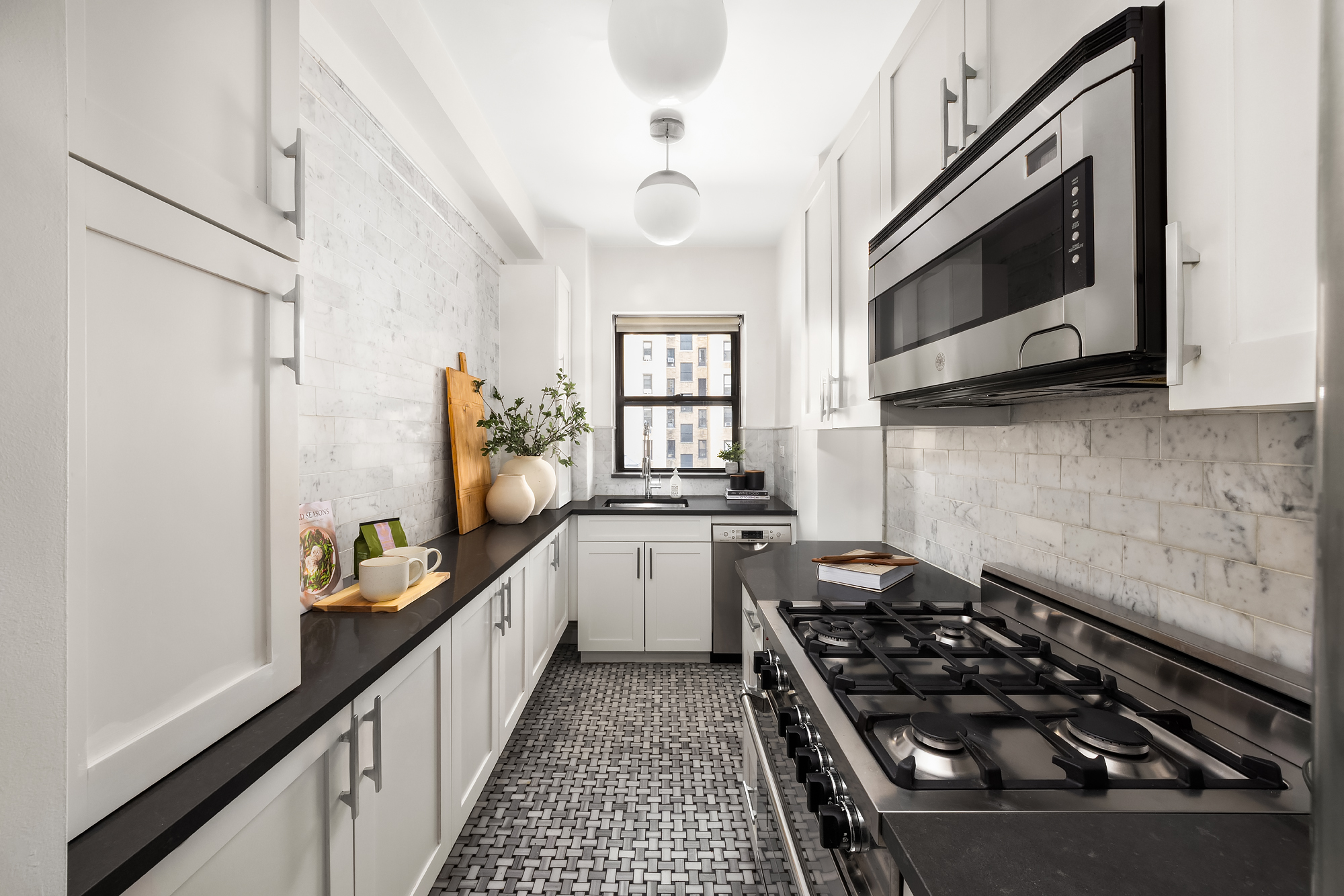 49 East 96th Street, Unit 9B Manhattan, NY 10128 - Photo 7 of 15 a kitchen with a stove and a white cabinet