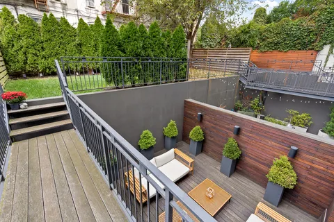 a view of a balcony with wooden floor and outdoor seating