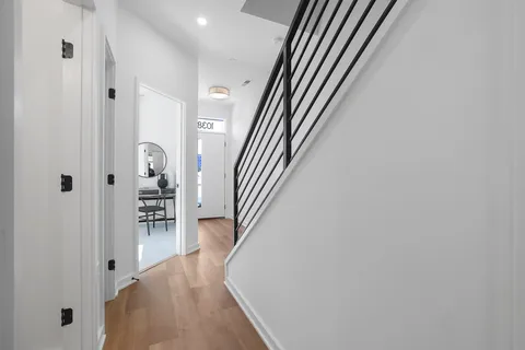 a view of a hallway with wooden floor and staircase