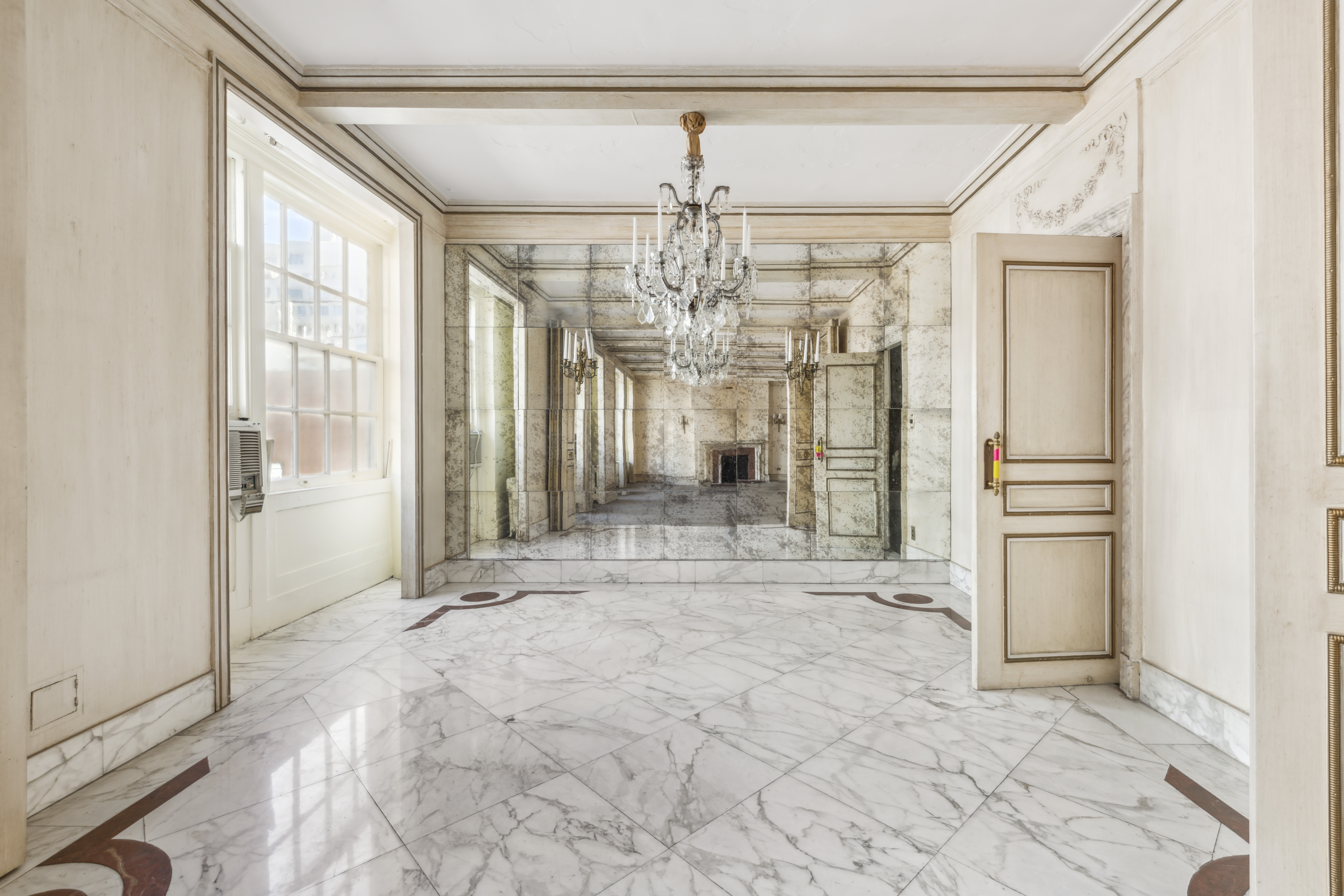 130 East 67th Street, Unit 9C Manhattan, NY 10065 - Photo 6 of 20 a view of a room with a chandelier and refrigerator