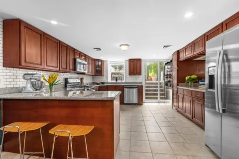 a kitchen with stainless steel appliances granite countertop a stove top oven a sink dishwasher and a refrigerator