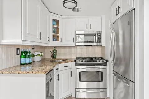 a kitchen with stainless steel appliances granite countertop a refrigerator sink and stove