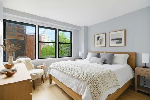 a bedroom with a bed and a large window