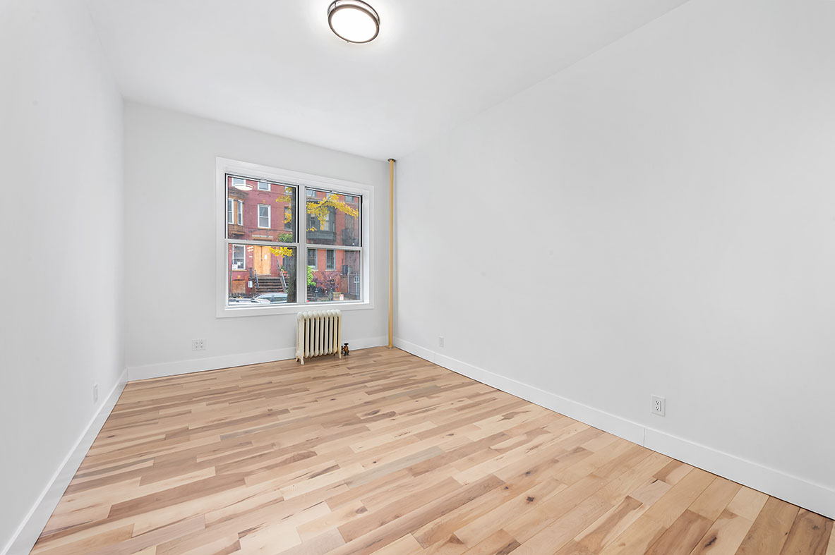 88 Brooklyn Avenue, Unit A3 Brooklyn, NY 11216 - Photo 4 of 12 a view of empty room with wooden floor and fan