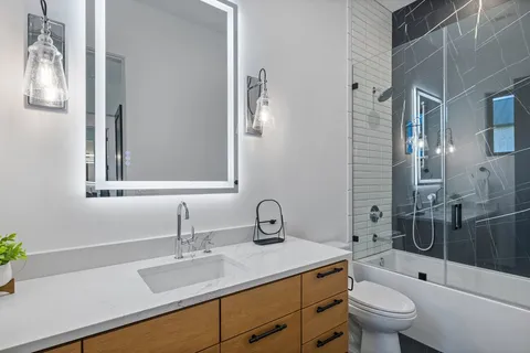 a bathroom with a sink toilet a mirror and shower