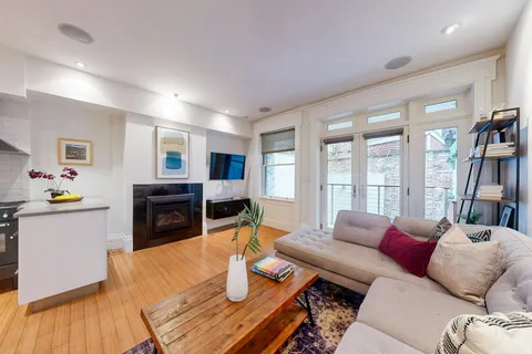 a living room with furniture a fireplace and a large window