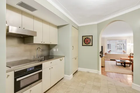 a kitchen with granite countertop a stove and white cabinets