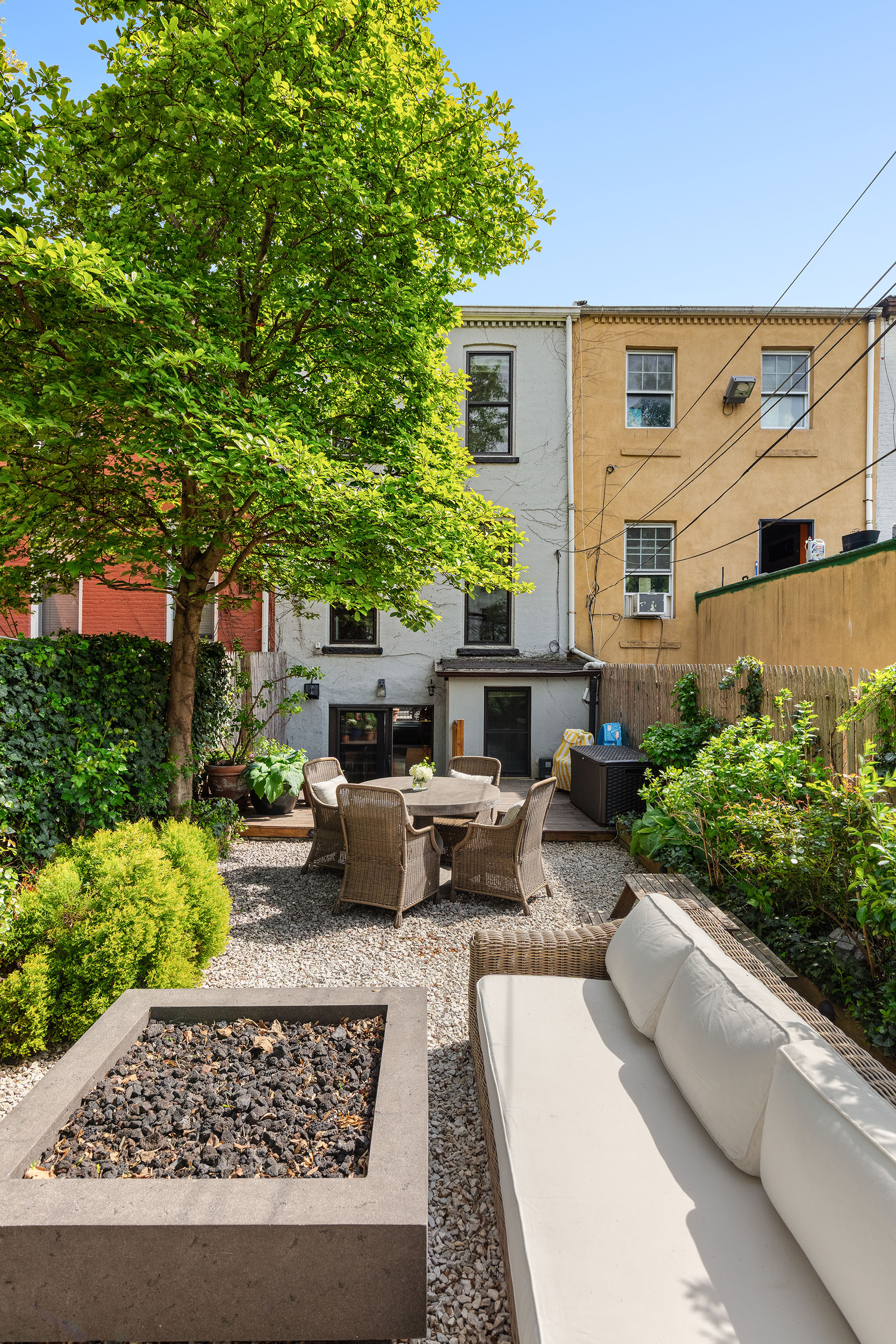 793 A Willoughby Avenue Brooklyn, NY 11206 - Photo 19 of 22 a view of a patio with couches table and chairs potted plants and large tree
