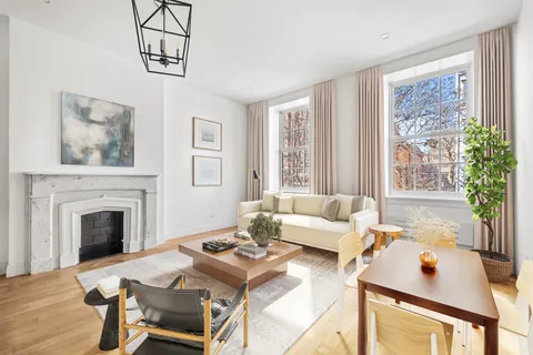 a living room with furniture a fireplace and a floor to ceiling window
