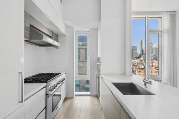 a kitchen with granite countertop a sink stove and refrigerator