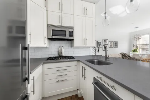 a kitchen with stainless steel appliances granite countertop a sink a stove and a microwave