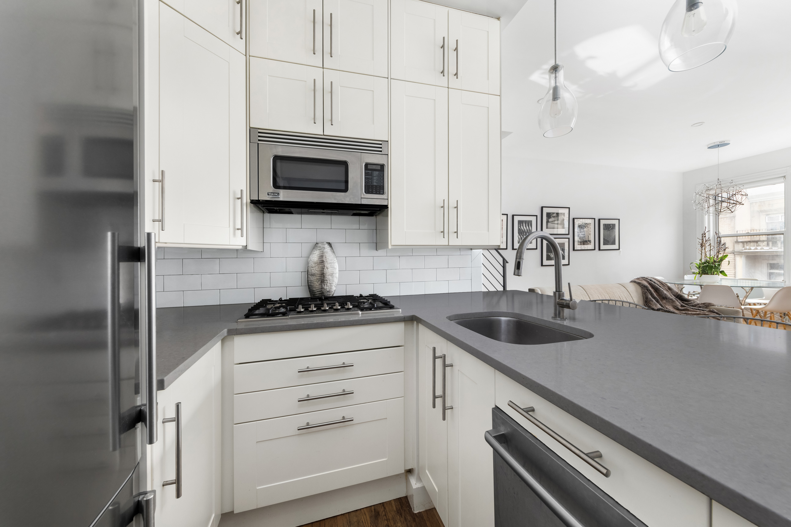 311 West 76th Street, Unit PH-5 Manhattan, NY 10023 - Photo 6 of 11 a kitchen with stainless steel appliances granite countertop a sink a stove and a microwave