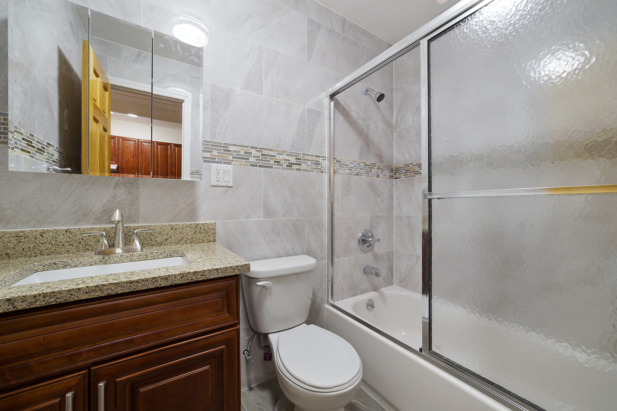 208 Lenox Road, Unit 3 Brooklyn, NY 11226 - Photo 5 of 7 a bathroom with a granite countertop sink toilet mirror and shower