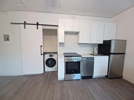 a kitchen with stainless steel appliances granite countertop a refrigerator a stove and a wooden floors