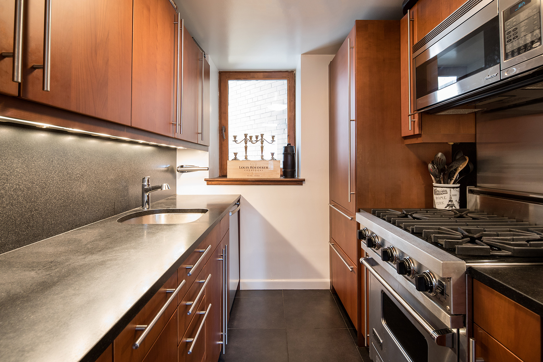 305 2nd Avenue, Unit 516 Manhattan, NY 10003 - Photo 4 of 21 a kitchen with stainless steel appliances granite countertop a stove and a microwave