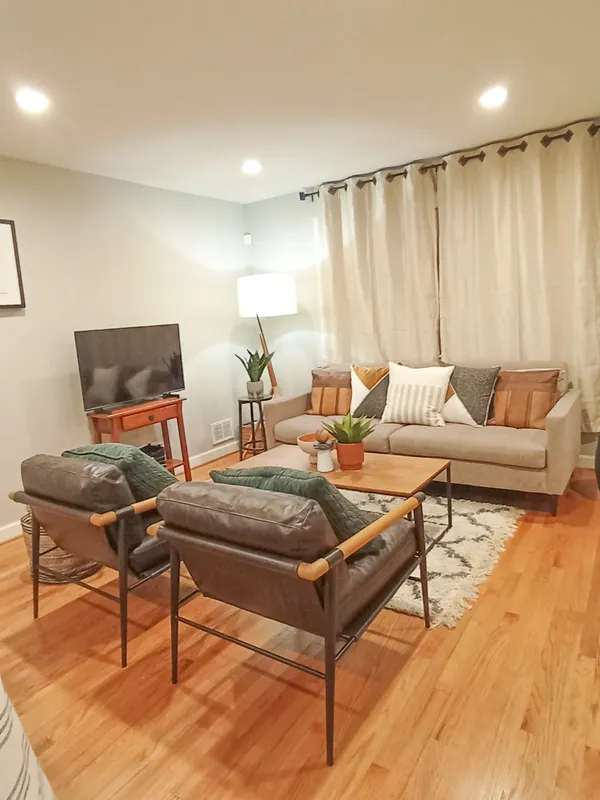 a living room with furniture and a wooden floor
