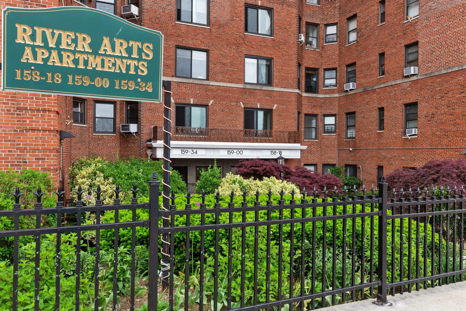 a front view of a multi story building with a yard