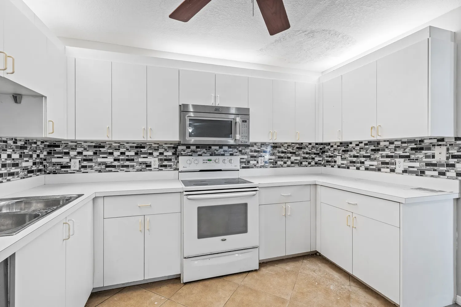 a kitchen with granite countertop white cabinets and white appliances
