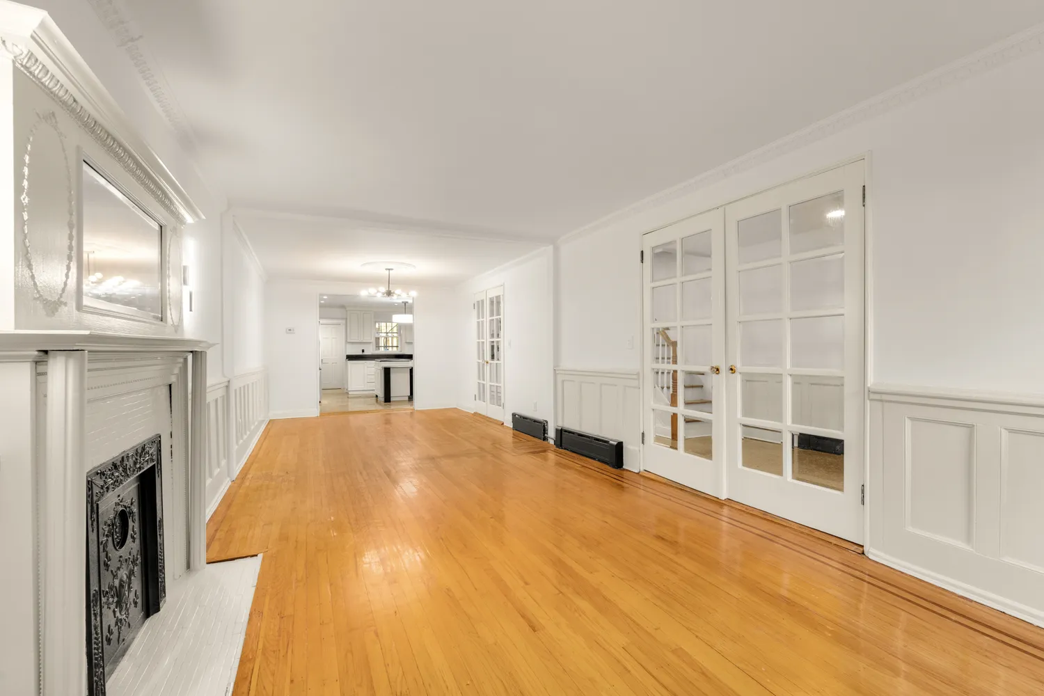 a big room with wooden floor and a fireplace