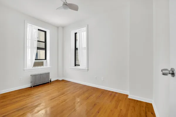 an empty room with a window and wooden floor
