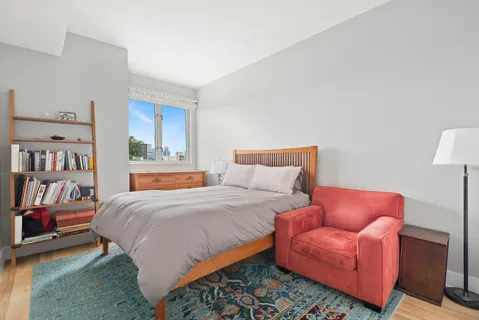 a bedroom with a bed couch and a book shelf