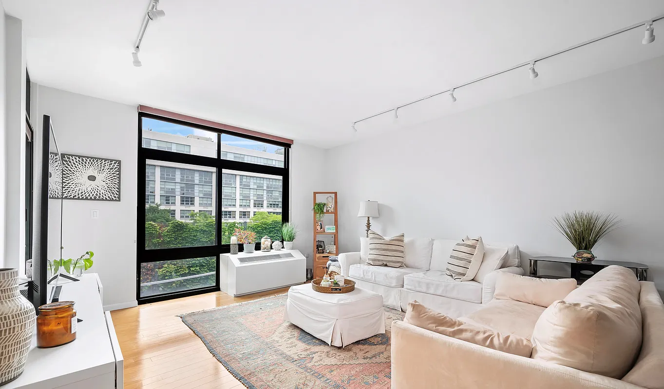 48-21 5th Street, Unit 3H Queens, NY 11101 - Photo 2 of 10 a living room with furniture and large windows