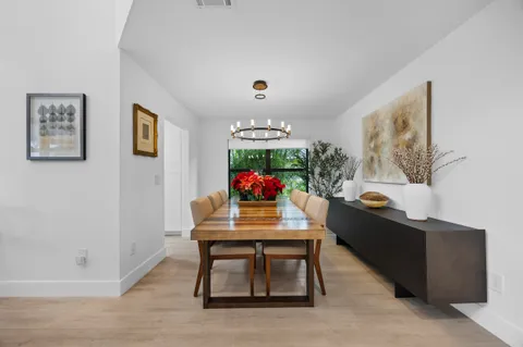 a view of a dining room with furniture a chandelier and wooden floor
