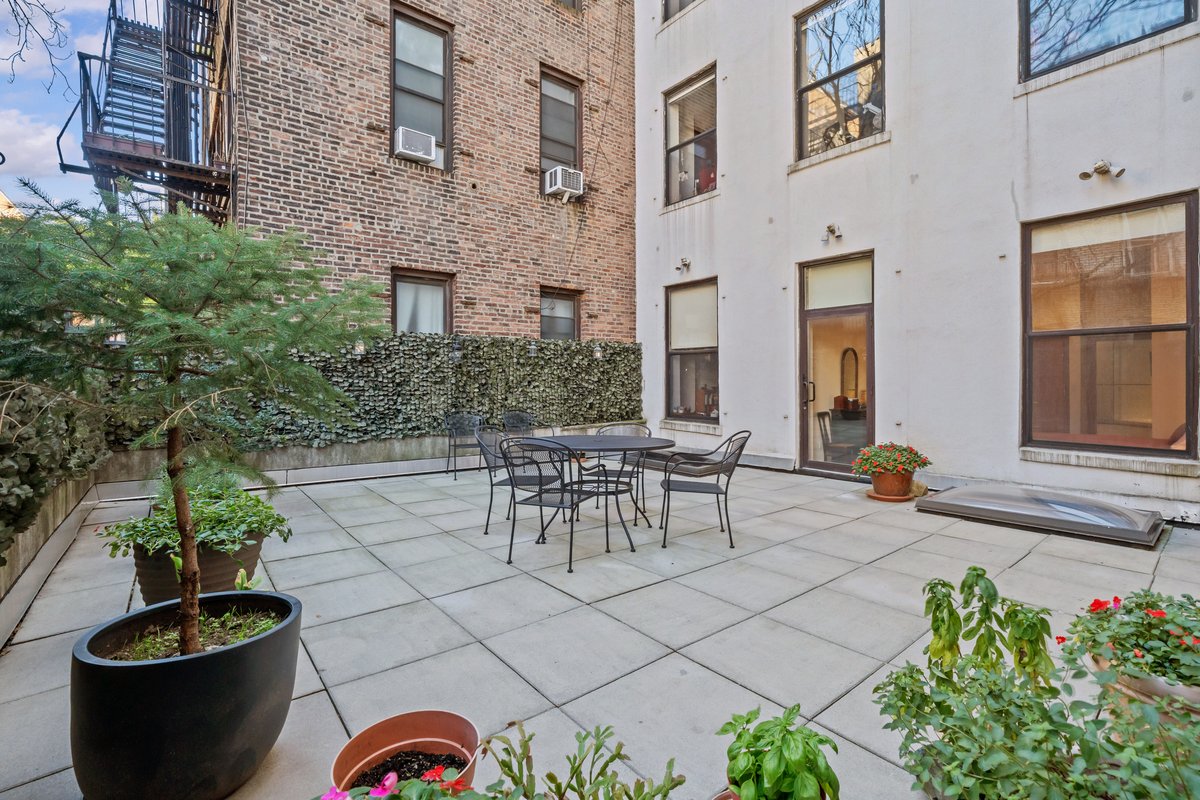 a view of a patio with table and chairs and potted plants