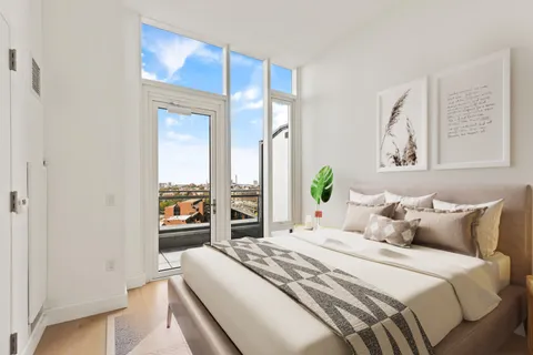 a bedroom with a balcony a bed and a painting on the wall
