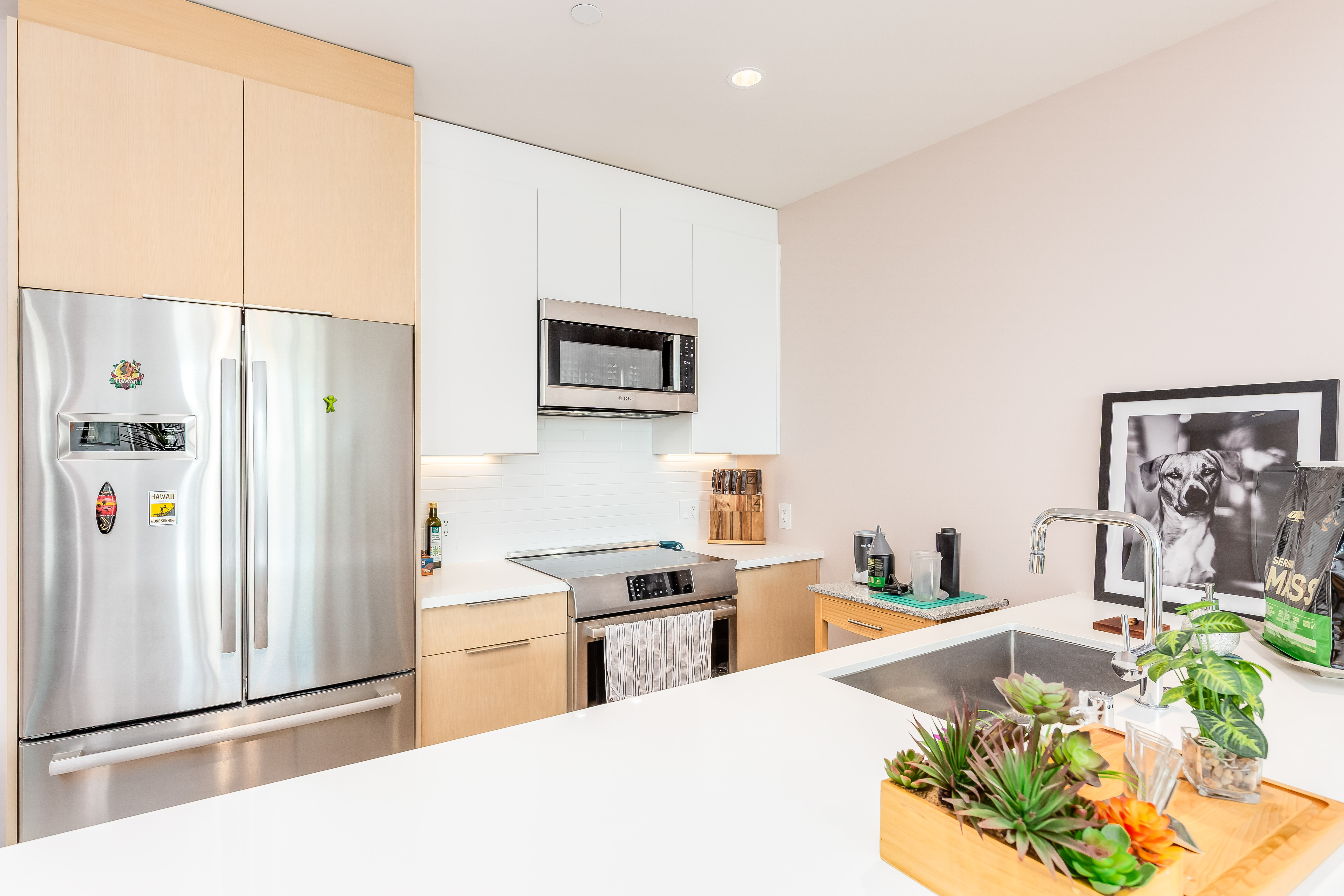 1001 Queen Street Honolulu, HI 96814 - Photo 6 of 29 a kitchen with stainless steel appliances a refrigerator a sink a stove a dining table and chairs with wooden floor