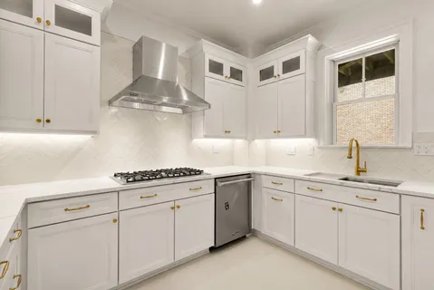a kitchen with white cabinets and white appliances