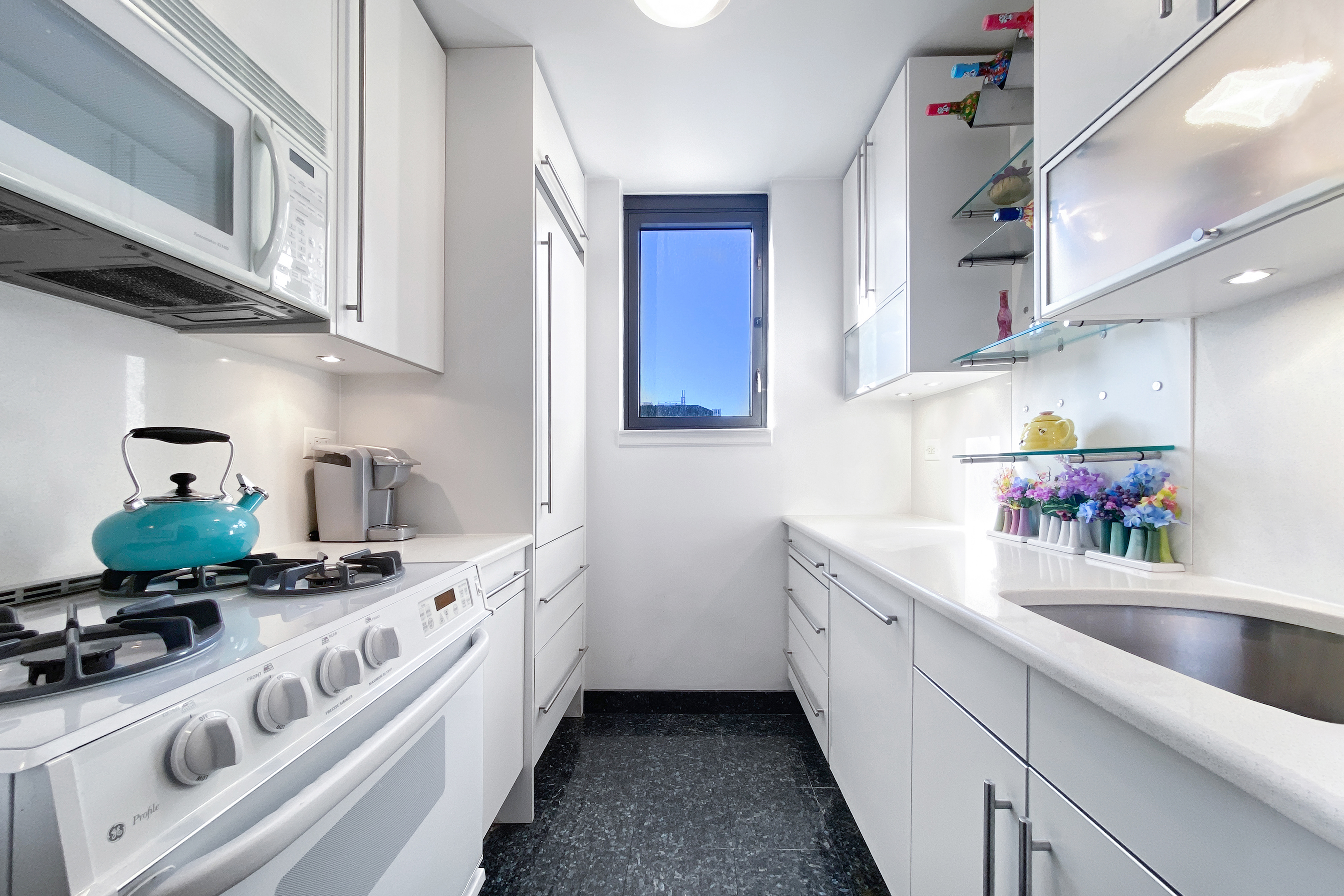330 East 38th Street, Unit 38E Manhattan, NY 10016 - Photo 12 of 35 a kitchen with stainless steel appliances a sink stove and cabinets
