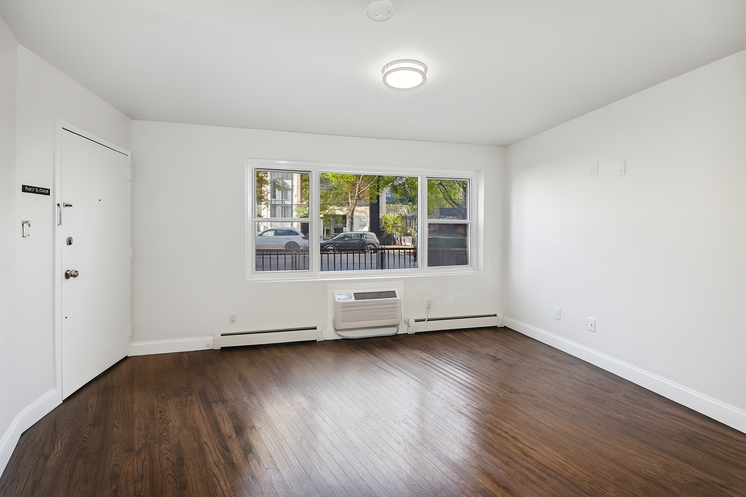189 Woodpoint Road Brooklyn, NY 11211 - Photo 14 of 21 an empty room with wooden floor and windows