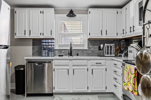 a kitchen with stainless steel appliances granite countertop a sink and cabinets