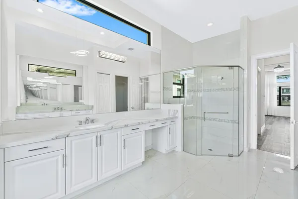 a spacious bathroom with a granite countertop sink and a mirror