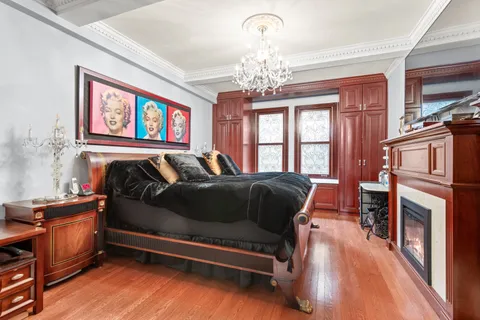 a bedroom with a bed and a dresser next to a window