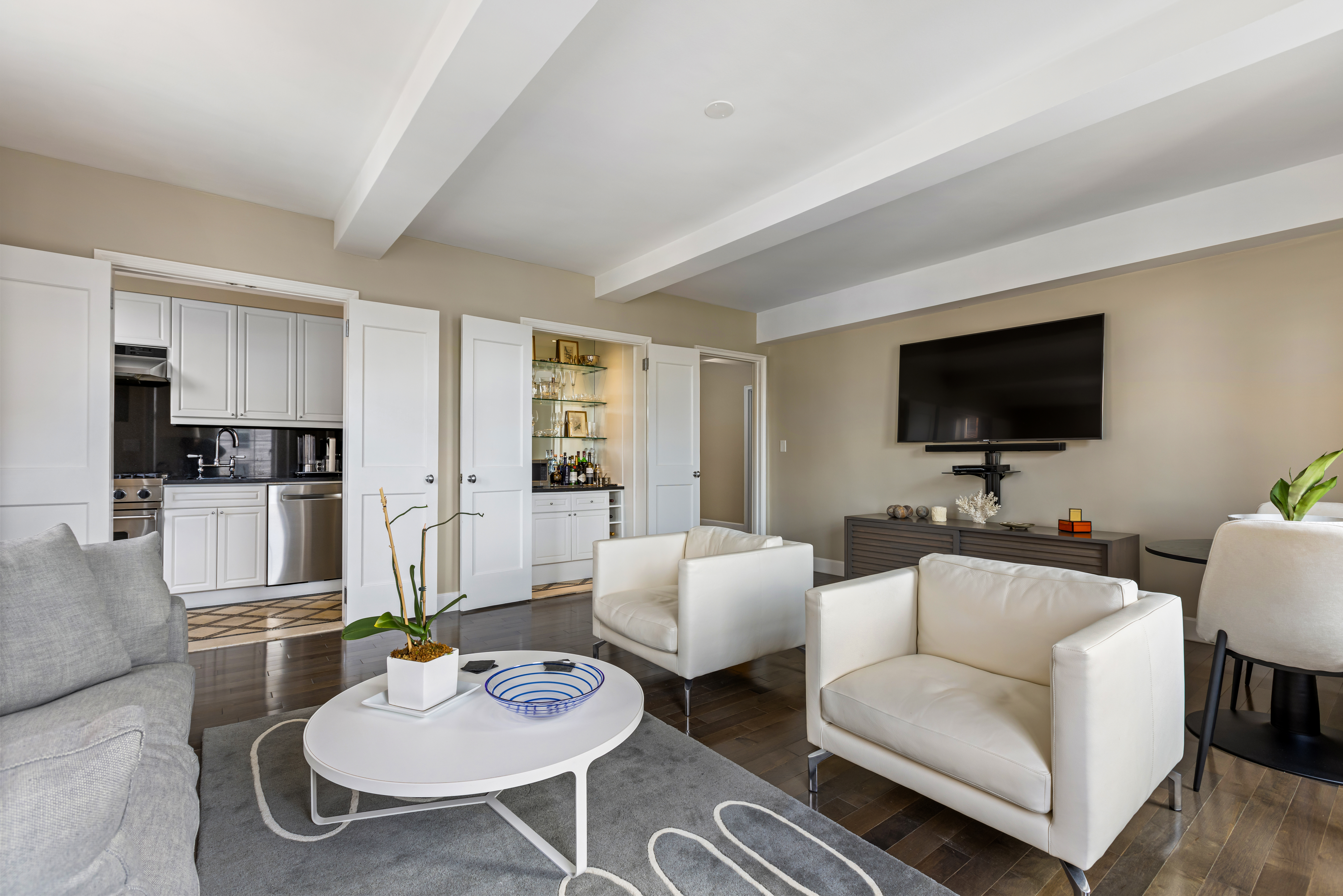 465 West 23rd Street, Unit 15B Manhattan, NY 10011 - Photo 3 of 19 a living room with furniture kitchen view and a flat screen tv