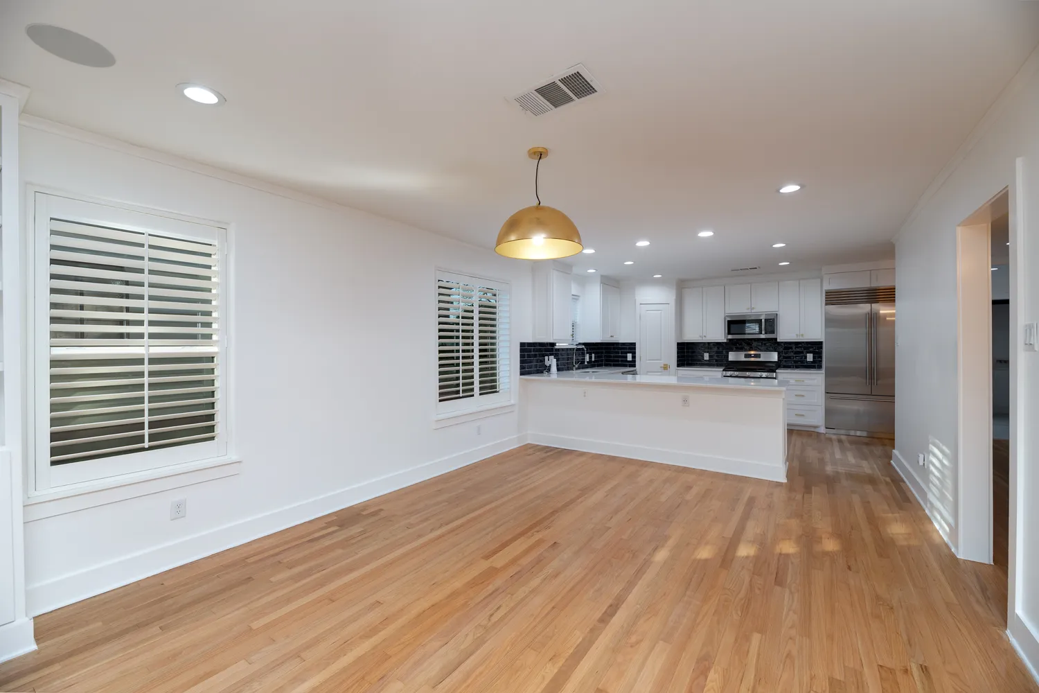 a view of kitchen with refrigerator stove and wooden floor