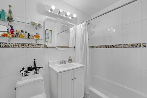 a bathroom with a sink mirror toilet and shower