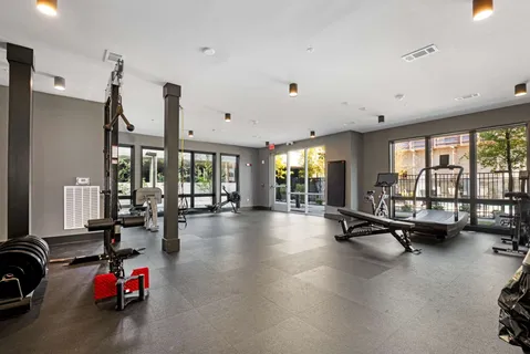 a living room with furniture gym equipment and a large window