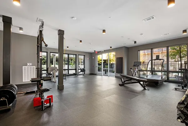 a living room with furniture gym equipment and a large window