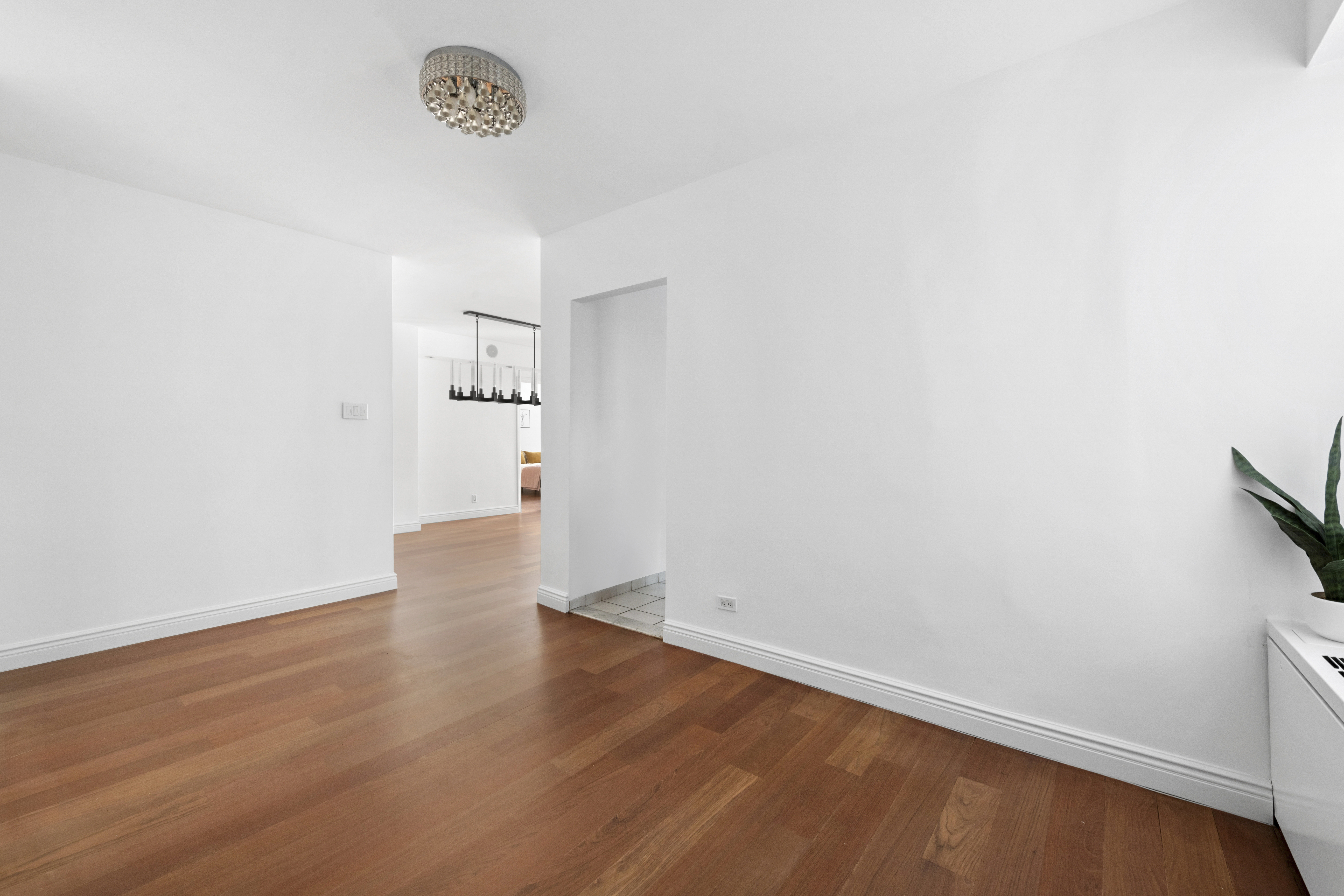 400 East 56th Street, Unit 3D Manhattan, NY 10022 - Photo 7 of 24 an empty room with wooden floor and white wall