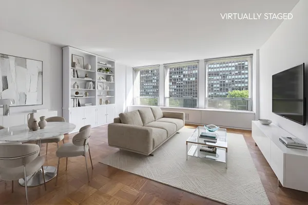 a living room with furniture a flat screen tv and a large window
