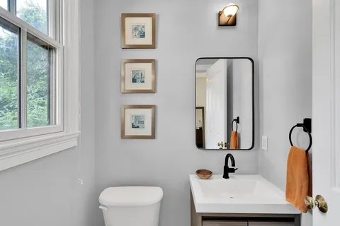 a bathroom with a toilet sink and mirror