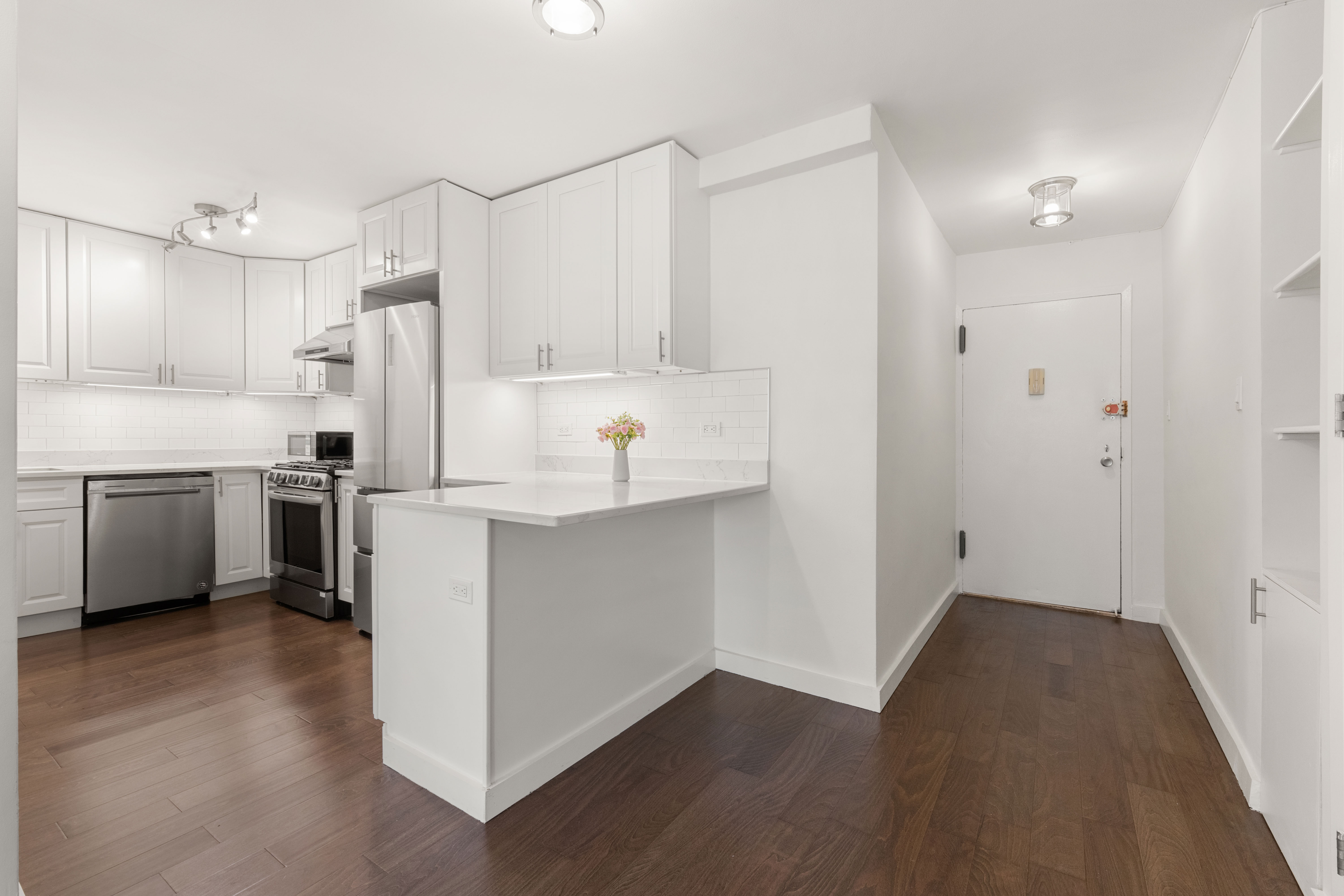 66-36 Yellowstone Boulevard, Unit 24A Queens, NY 11375 - Photo 5 of 20 a kitchen with kitchen island white cabinets and stainless steel appliances
