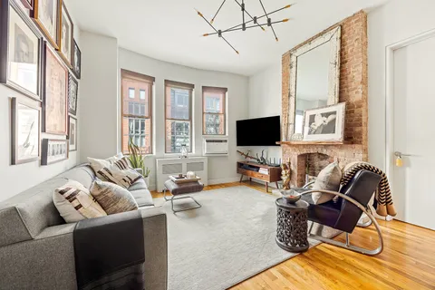 a living room with furniture a flat screen tv and a floor to ceiling window