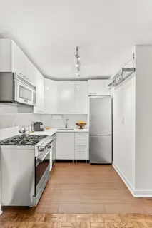 a kitchen with a stove top oven cabinets and a refrigerator
