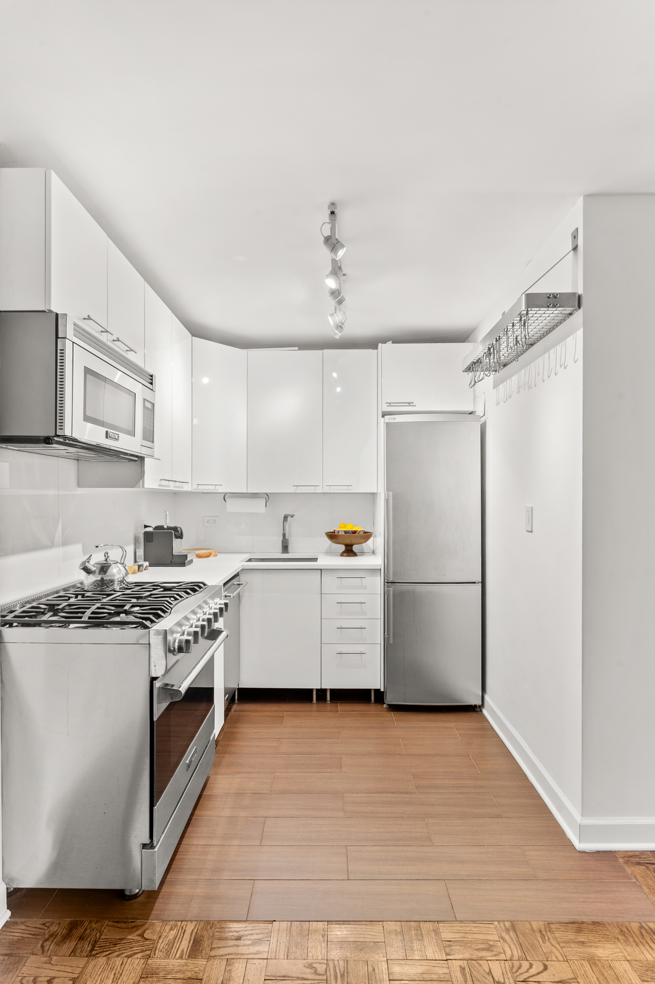251 East 51st Street, Unit 5A Manhattan, NY 10022 - Photo 11 of 23 a kitchen with a stove top oven cabinets and a refrigerator