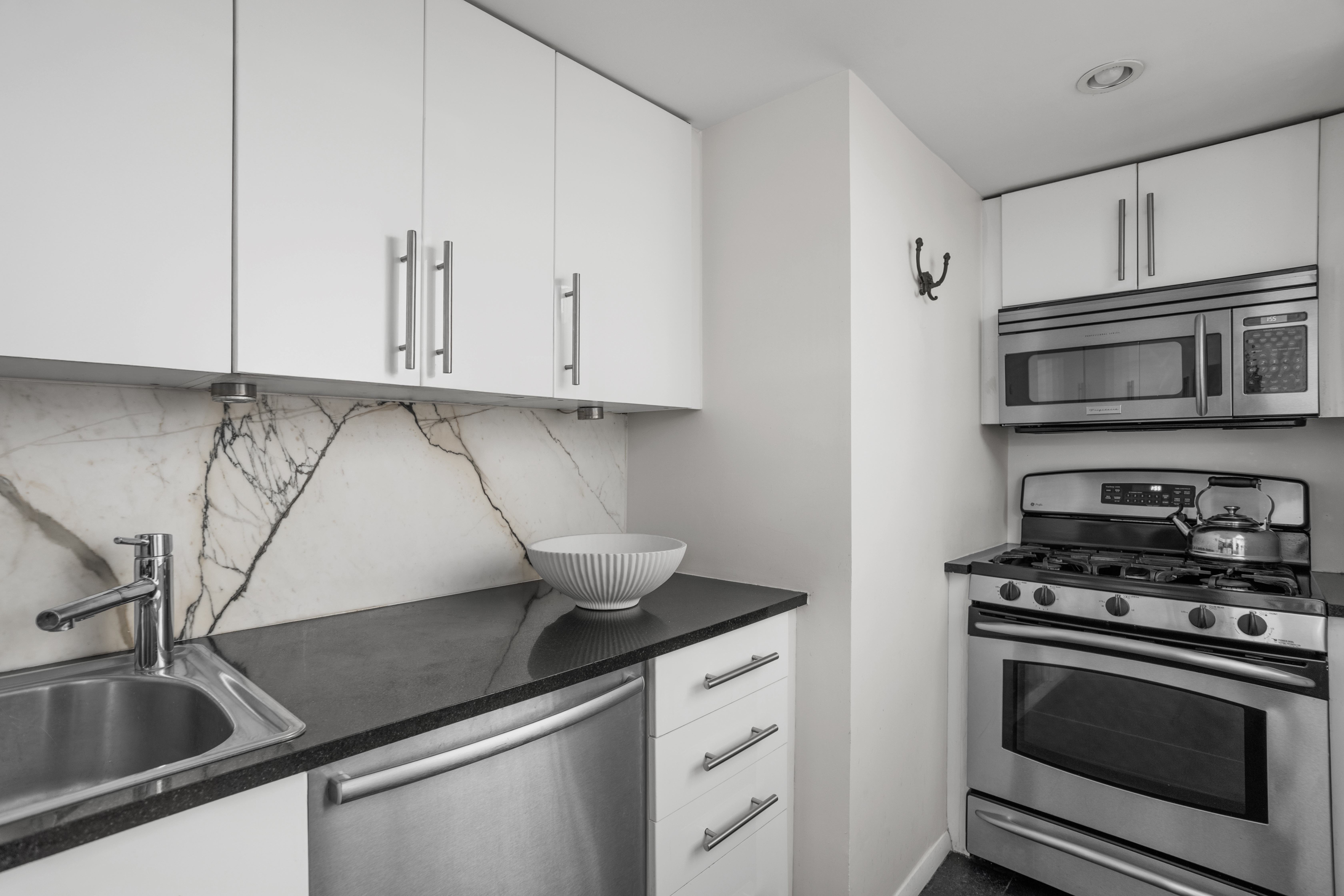 372 5th Avenue, Unit 3M Manhattan, NY 10018 - Photo 4 of 14 a kitchen with stainless steel appliances granite countertop a sink a stove and cabinets